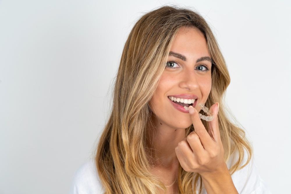 woman holding clear aligners 