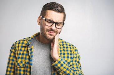 man holding jaw from tooth pain before root canal