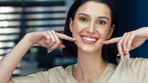 troy woman pointing to her smile