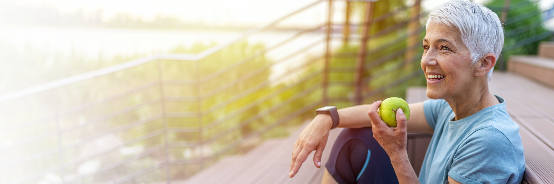 woman holding a green apple while sitting on her stairs