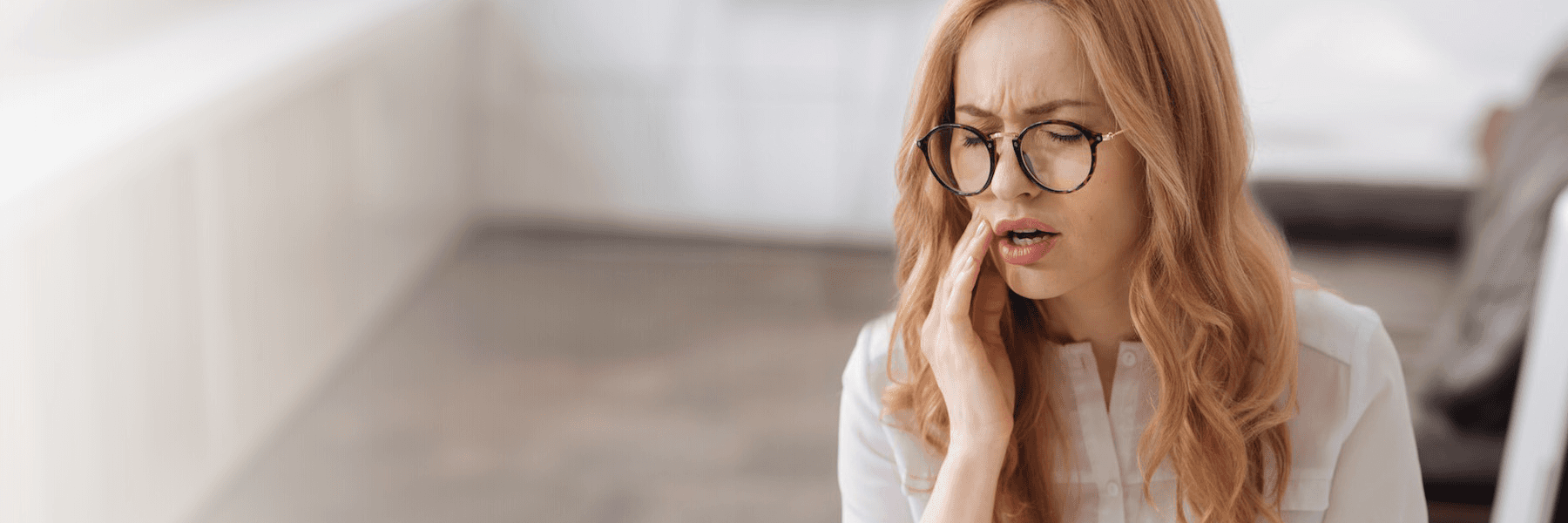 woman holding jaw from tooth pain