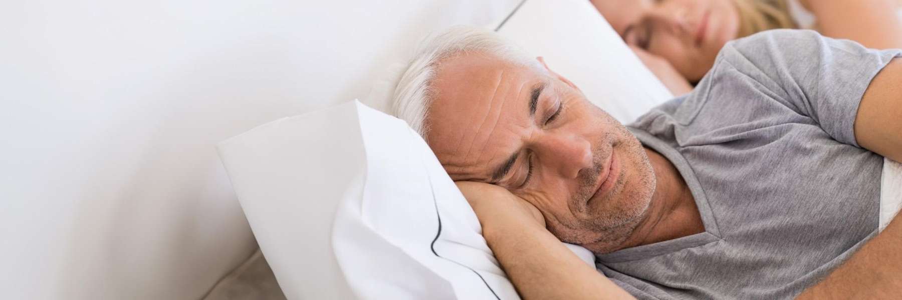 man sleeping peacefully with wife sleeping behind him