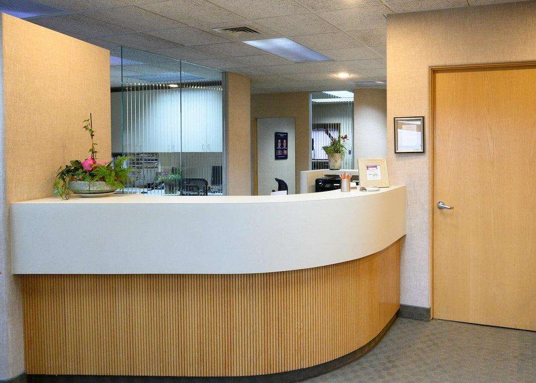Contemporary reception desk with a smooth, curved white counter in a modern office environment in troy