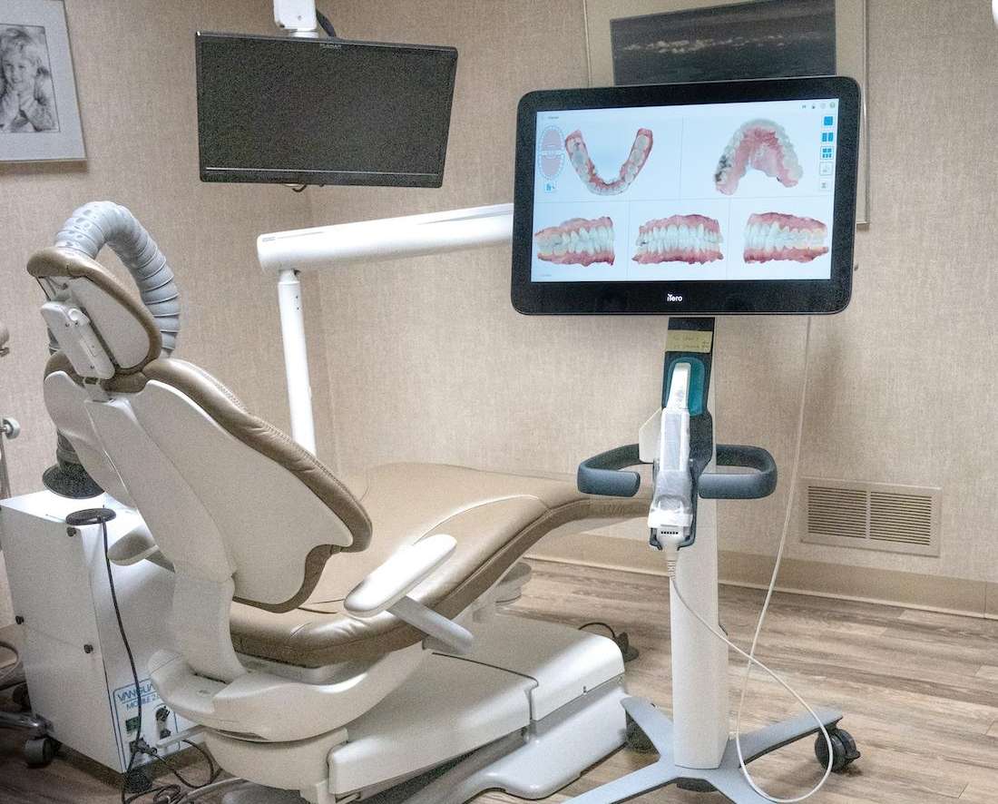 A modern dental chair featuring a monitor and computer in troy
