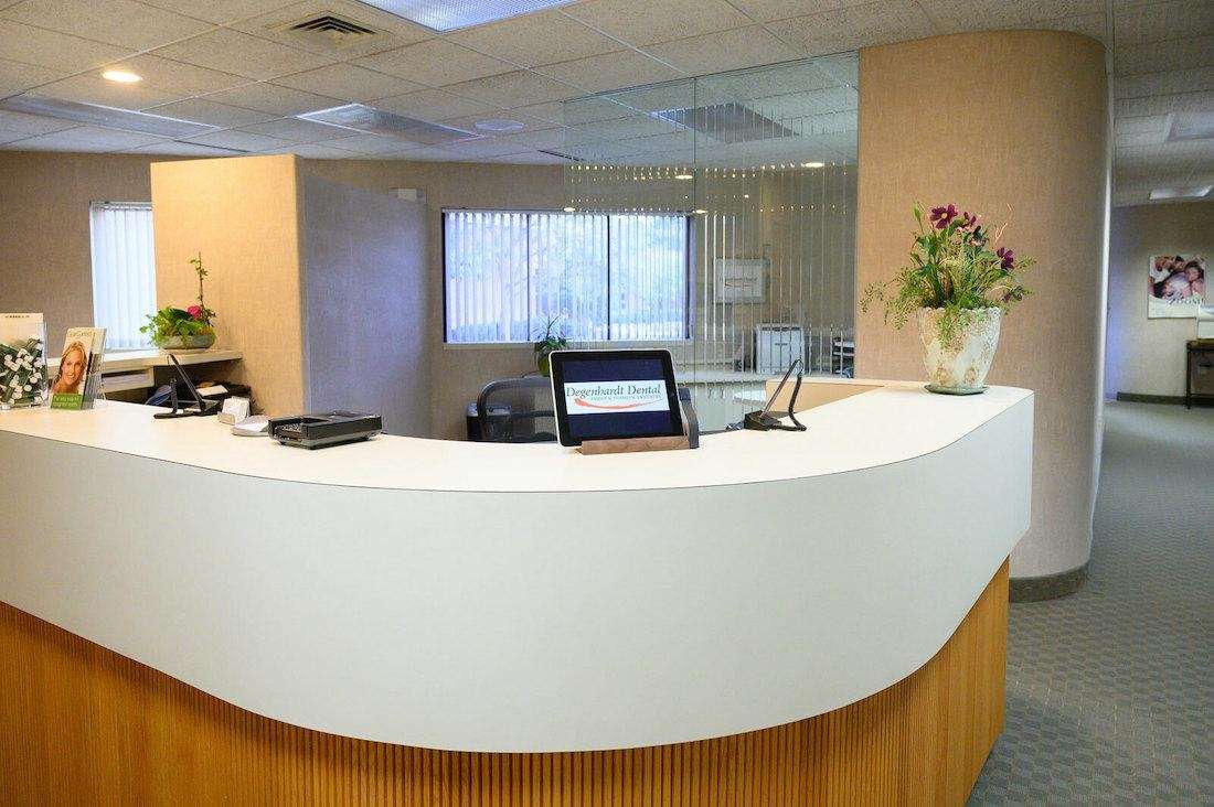 Modern reception desk at Troy dental office equipped with a laptop, set in a stylish office environment.